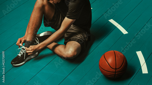 Basketball player tying his shoelaces wallpaper