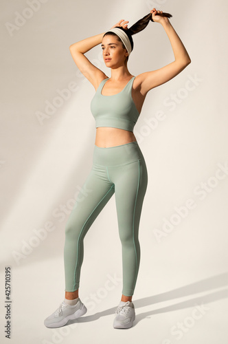 Woman in green sports bra and yoga pants activewear apparel full body