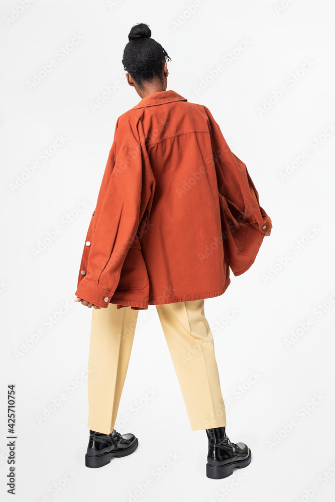 Woman in orange oversized jacket street style apparel rear view Woman in orange oversized jacket street style apparel rear view