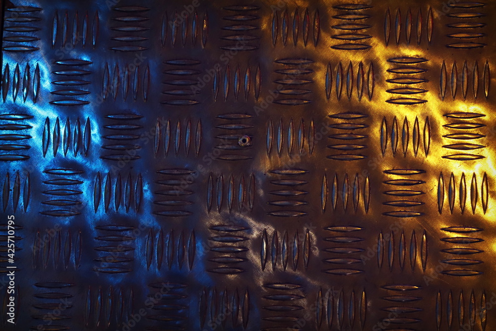 Obraz premium The texture of corrugated metal illuminated by blue and yellow spotlights