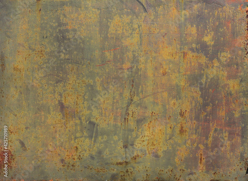 rusty metal discolored surface with yellow, green and gray natural tones - worn background with scratches and lichens for a wallpaper photo