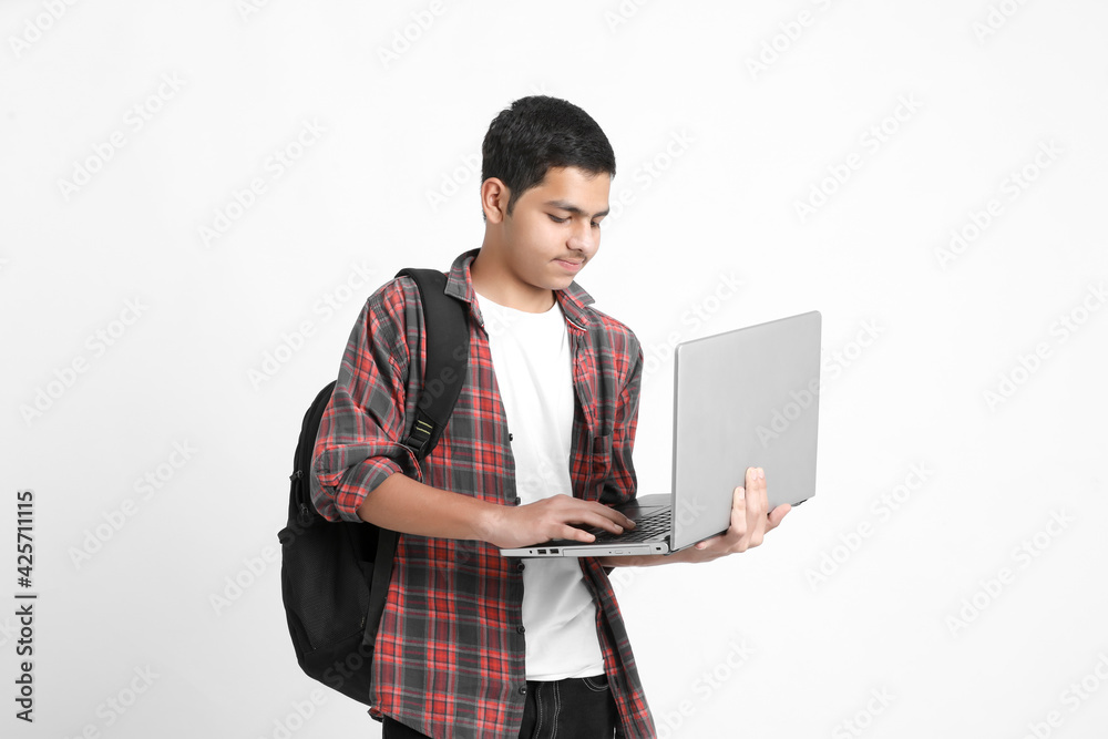 Indian college student using laptop on white background. Indian college student using laptop on white background.