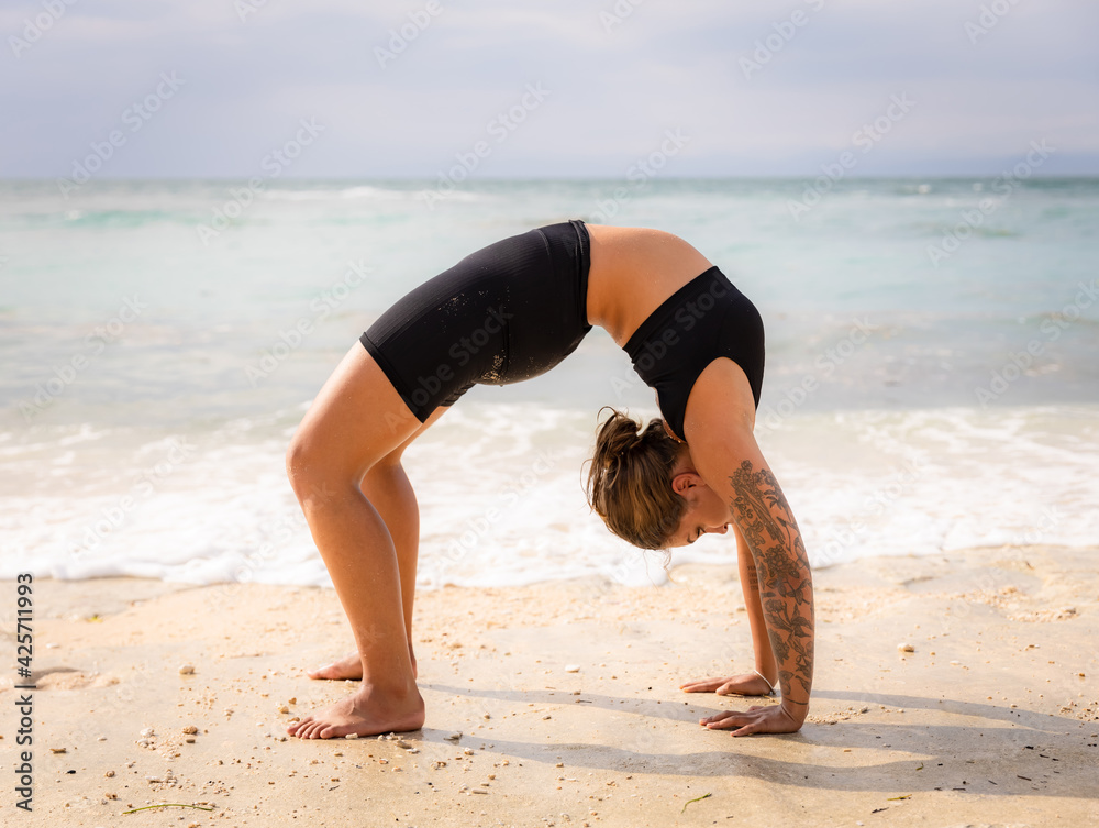 Benefits Guide To Wheel Pose Mukha Yoga beach-yoga-young-woman-practicing-chakrasana-or-urdhva-dhanurasana