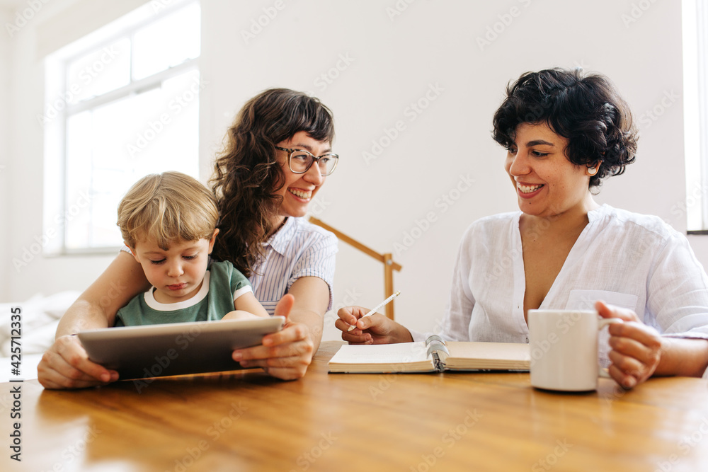 Smiling female couple with son using tablet pc Smiling female couple with son using tablet pc
