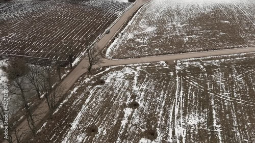 Aerial view with countryside road and snow covered plowed agriculture fields