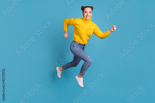 Full body profile photo of cheerful excited girl jump running look camera isolated on blue color background