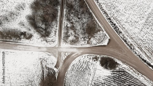 Aerial view with countryside road and snow covered plowed agriculture fields