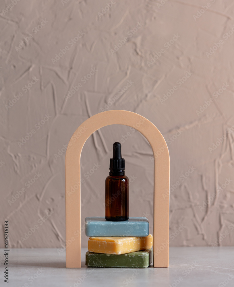 Dark bath bottle and soap on arch decorated background