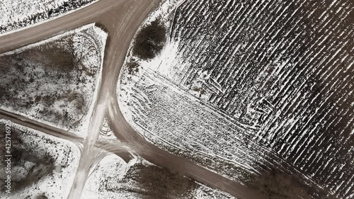 Aerial view with countryside road and snow covered plowed agriculture fields
