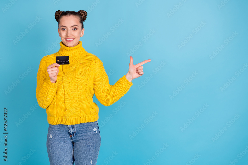 Portrait of attractive cheerful girl holding in hand bank card demonstrating copy space isolated over bright blue color background Portrait of attractive cheerful girl holding in hand bank card demonstrating copy space isolated over bright blue color background