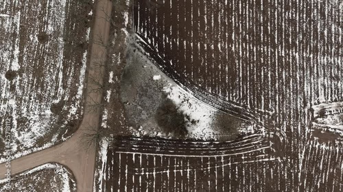 Aerial view with countryside road and snow covered plowed agriculture fields