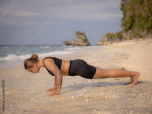 Yoga pose. Caucasian woman practicing Phalakasana, Plank Pose. Strong body. Healthy lifestyle. Self-care concept. Yoga retreat. Thomas beach, Bali