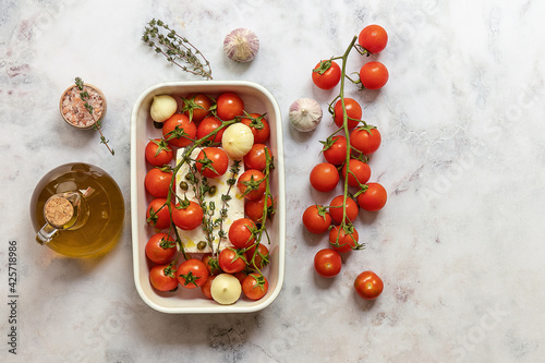 Preparing to bake feta cheese with tomatoes, capers, garlic, herbs, and olive oil. In the oven it turns into an amazing sauce by itself. Just add some cooked pasta, mix, and enjoy. 