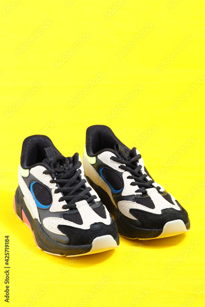 Stylish leather sneakers in isolation, on a yellow background. High quality photo