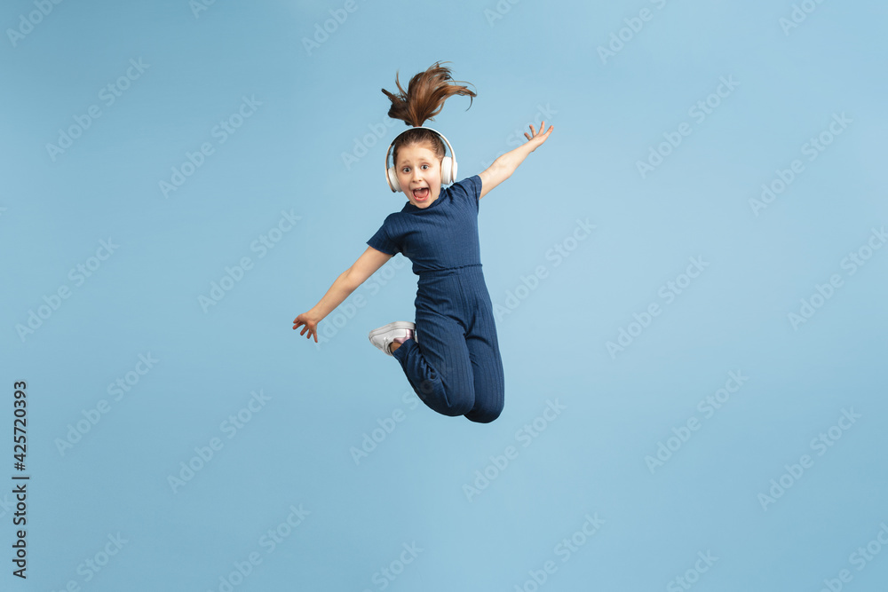 Pretty caucasian girl portrait isolated on blue studio background with copyspace Pretty caucasian girl portrait isolated on blue studio background with copyspace