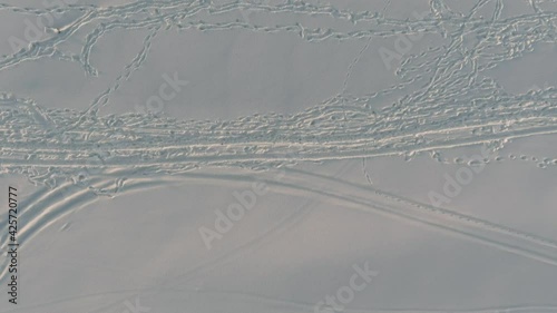 Snow covered beach with many hiker tracks as seen from drone