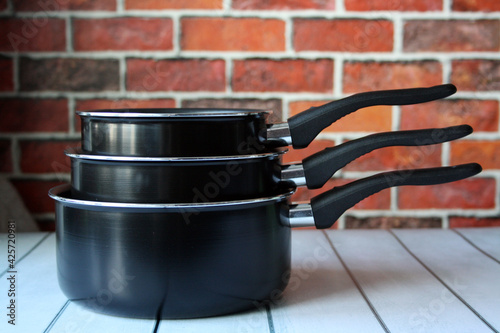 Billede på lærred Ladles for cooking on a wooden table. Pot with handle