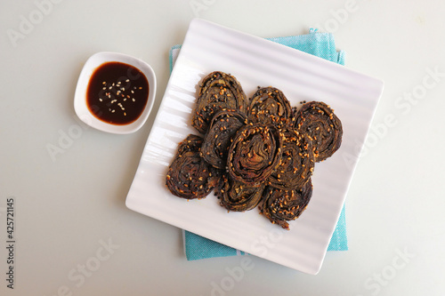 Alu Vadi, Patra, paatra, colocasia leaves roll, Patrode is a popular Indian healthy steamed snack. Garnished with sesame and mustard seeds. served with tamarind chutney. copy space. photo