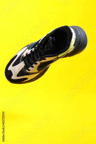 Sneakers on a yellow background. Stylish sports shoes, close-up, isolated, levitation. High quality photo