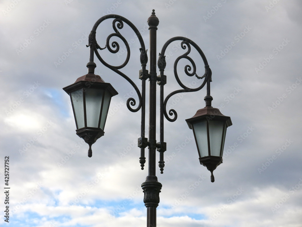 beautiful forged vintage lantern on a gray sky background