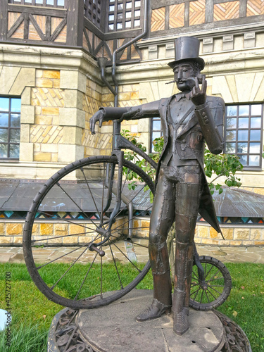 Canvas Print statue of a cyclist in a top hat and with an old-fashioned bicycle from the begi