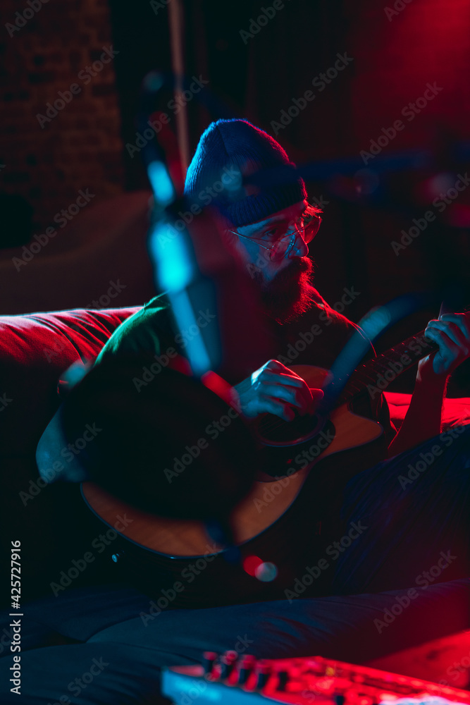 Close-up of musician performing in neon light. Concept of advertising, hobby, music, festival, entertainment.