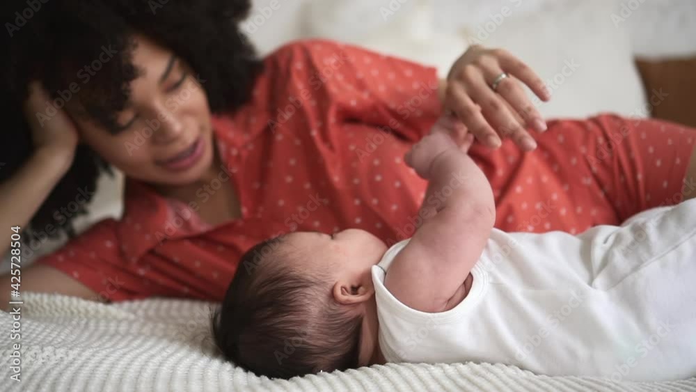 Woman touching and talking with toddler while lying on bed in home bedroom spbd. Woman touching and talking with toddler while lying on bed in home bedroom spbd.
