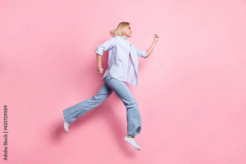 Full size profile photo of energetic girl look empty space running hurry isolated on pink color background Full size profile photo of energetic girl look empty space running hurry isolated on pink color background