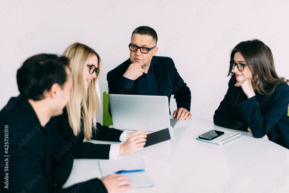 Business people showing team work while working in board room in office interior. People helping one of their colleague to finish new business plan. Business concept. Team work. Business people showing team work while working in board room in office interior. People helping one of their colleague to finish new business plan. Business concept. Team work.