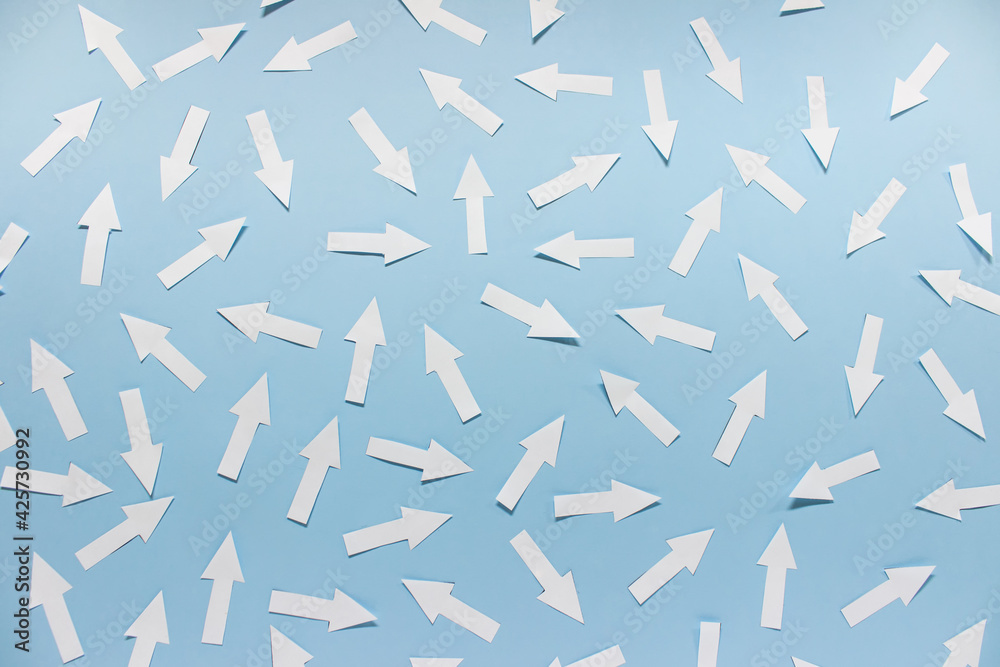 Concept of chaos randomly arranged many white paper arrows on blue background. - obrazy, fototapety, plakaty 