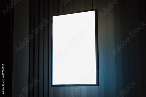 A4 vertical glowing light box mockup template at night.