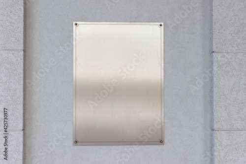 Wallpaper Mural Mockup template empty blank vertical metallic stainless steel sign board on gray wall. Torontodigital.ca
