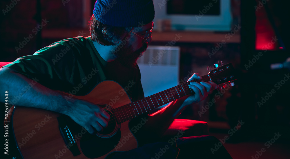 Obraz premium Close-up of musician performing in neon light. Concept of advertising, hobby, music, festival, entertainment.