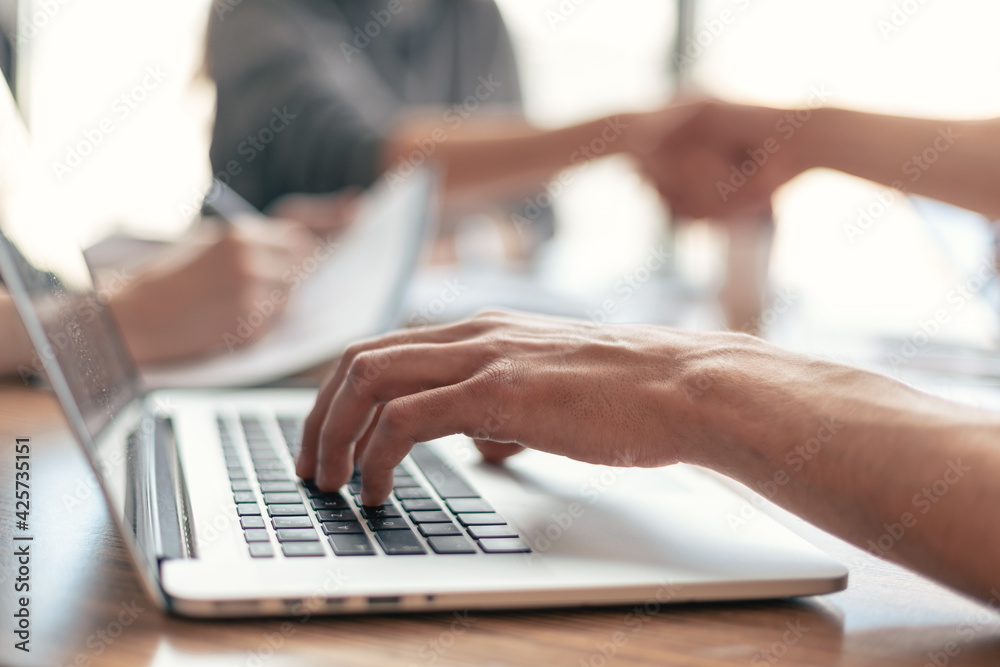 close up. businessman works on a laptop while sitting at an office Desk . close up. businessman works on a laptop while sitting at an office Desk .