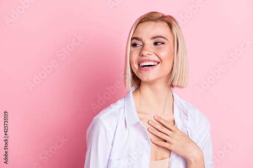 Photo of attractive cheerful young woman look empty space laugh joke comic isolated on pink color background