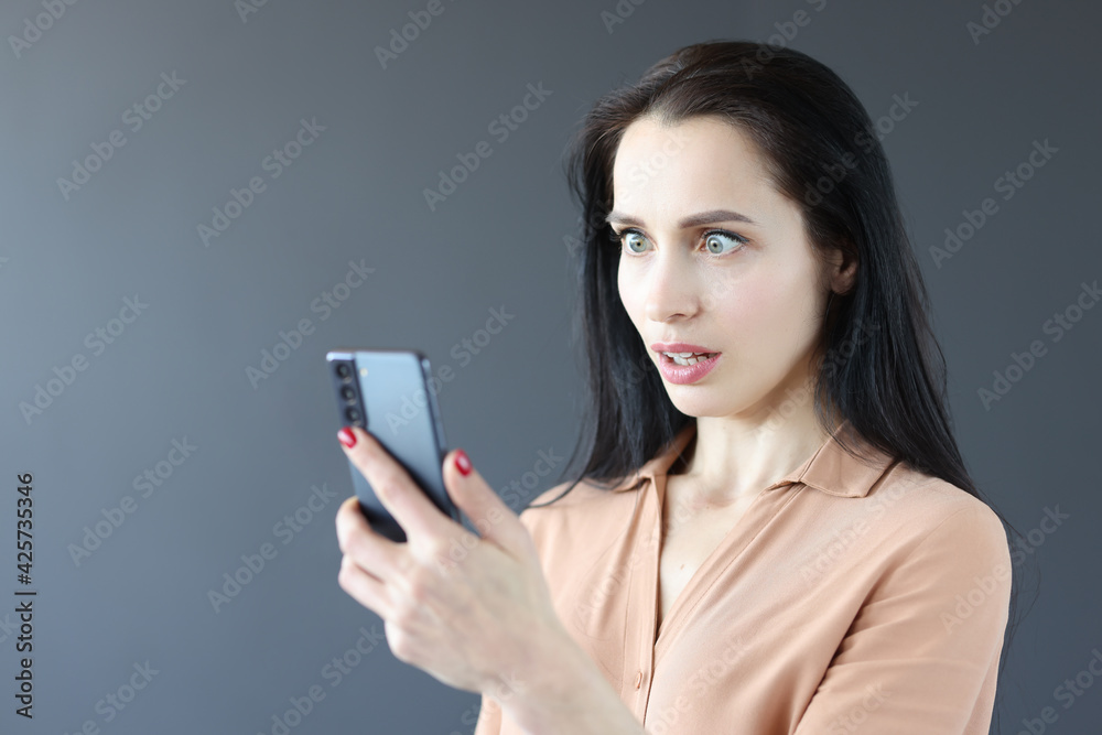 Portrait of surprised woman looking at smartphone Portrait of surprised woman looking at smartphone