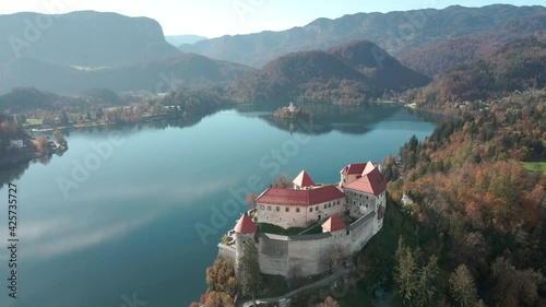 Beautiful aerial dolly overlooking clifftop castle lake bled Slovenia sunny day photo