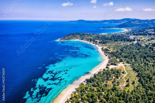 Beautiful Beach With Golden Sand And Clear Water. Turquoise coast with blue water and golden sand in Europe. Summer vacation background with turquoise sea water bay and pine trees aerial drone photo © Chawran