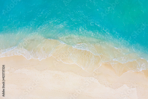 Top view on coast waves on beach aerial view, crystal clear water. Stunning summer landscape, sunny tropical island shore. Seaside, idyllic nature Earth view. Stunning scenery, amazing view © icemanphotos