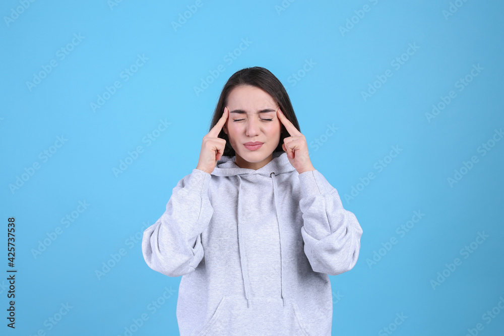 Portrait of stressed young woman on light blue background Portrait of stressed young woman on light blue background
