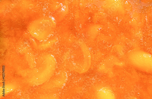 Texture, background of apricot jam. Orange fruit. Home-made for the winter. The view from the top.