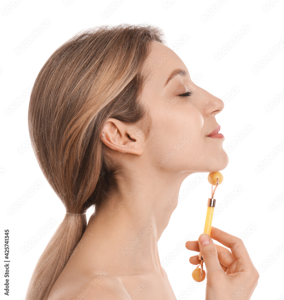 Young woman using natural jade face roller on white background Young woman using natural jade face roller on white background