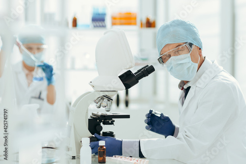 scientist using a microscope in a biochemical laboratory.