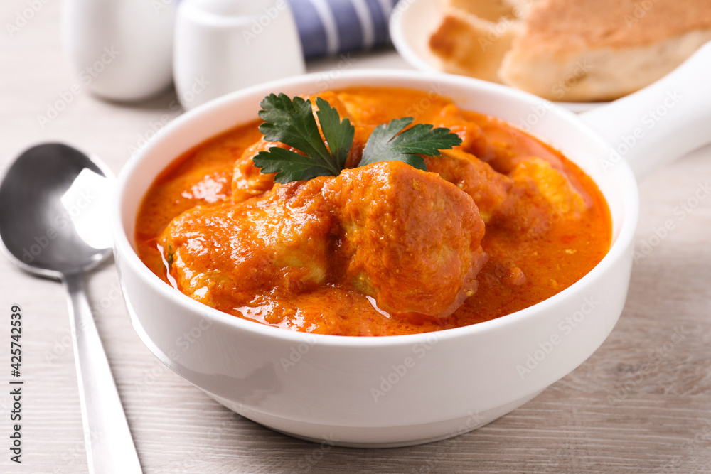 Bowl of delicious chicken curry on white wooden table Bowl of delicious chicken curry on white wooden table
