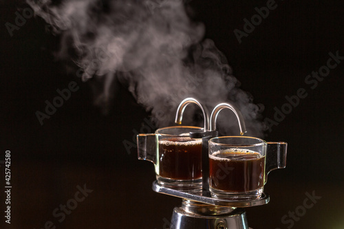Heat vapor emitted from the coffee machine..Two black coffeemakers in a black background. hot coffee and the heat vapor is gushed out from the coffee percolator tube..