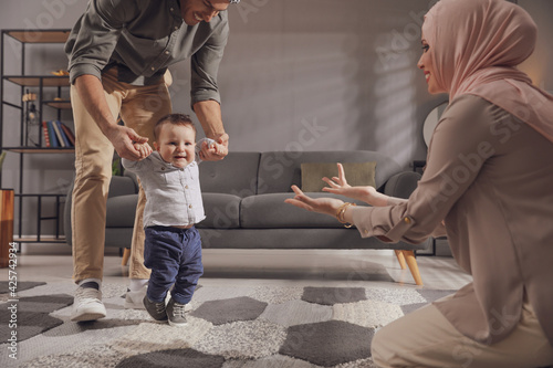 Canvas Print Happy Muslim family with little son in living room