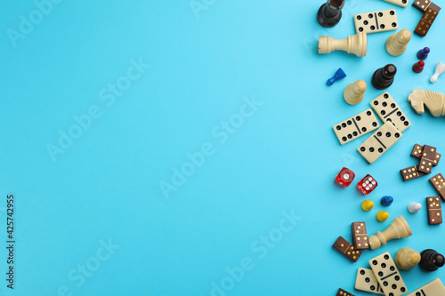 Fototapeta Components of board games on light blue background, flat lay
