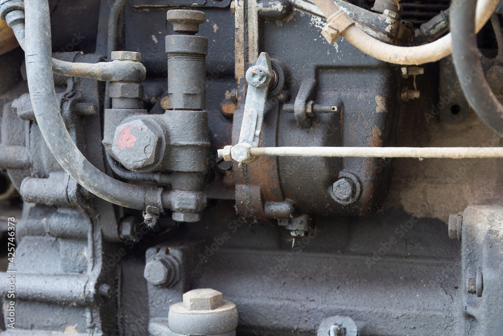 Part of tractor diesel engine with dark oil drips and dust