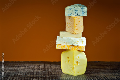 Wallpaper Mural Yellow piece of cheese on an orange background. Different types of cheese piles. Tower of pieces of cheese. Copy space and free space for text near the cheese. Torontodigital.ca