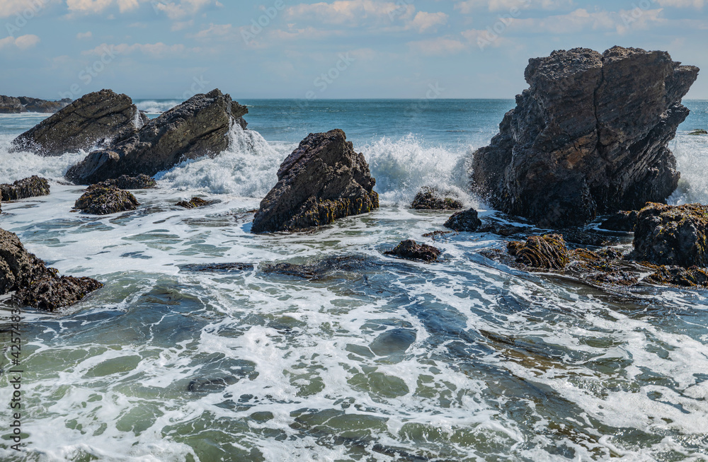 Beautiful seascape of the Pacific coast in California, waves, rocks, sky, sun. Concept, perfect postcard and guide.